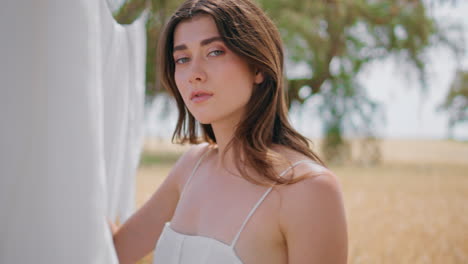chica rural disfrutando del verano jardín de aire fresco de cerca. mujer joven mirando cámara
