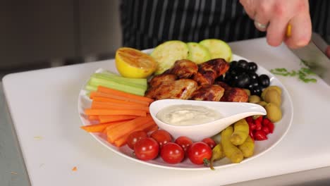 chef preparing a delicious chicken wings and vegetable platter