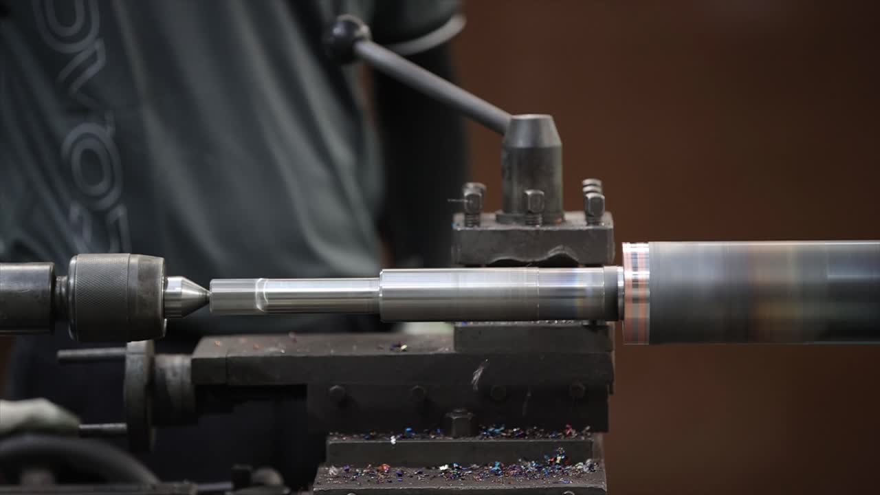 Obrabiany obracający się przemysłowy element stalowy na tokarce w zakładzie obróbki metali