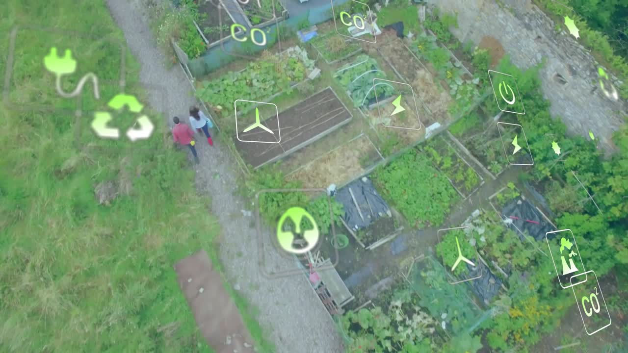 Un drone si alza sopra un appezzamento di terreno mentre una coppia cammina lungo un sentiero di ghiaia sotto icone di energia fluttuanti.
