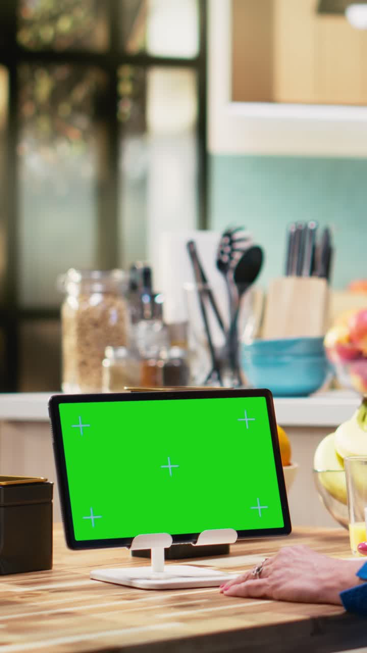 Vertical Video Isolated mockup tablet with old woman enjoying breakfast at kitchen table