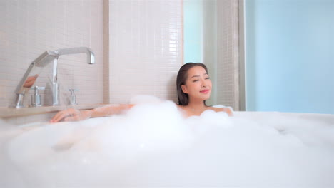 Hübsche-Asiatische-Frau-In-Voller-Schaumiger-Badewanne-Genießen-Und-Entspannen,-Verschwenderisches-Lifestyle-konzept,-Vollbild