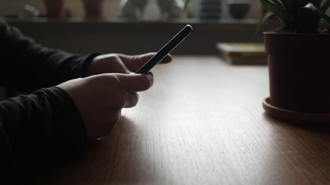 Bored female hands take smartphone and put in down on the table