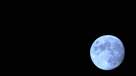 superluna llena ascendiendo en el cielo nocturno durante el crepúsculo astronómico