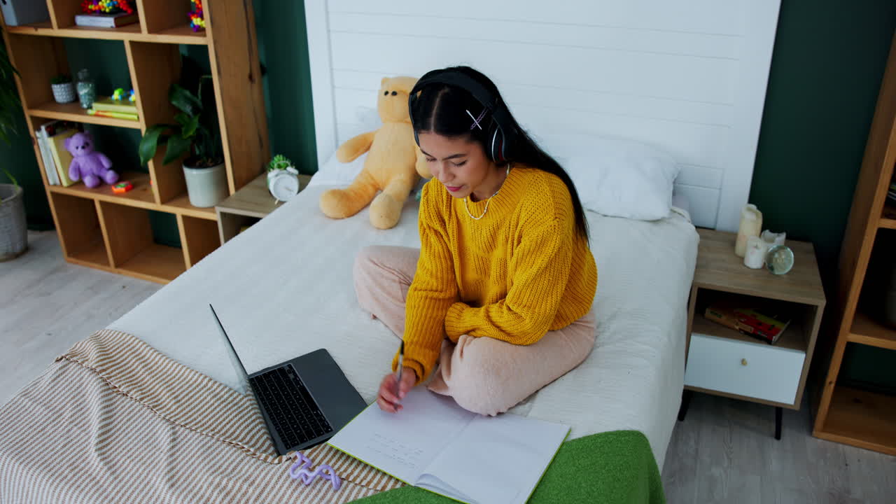 Mulher Estudando com Notebook e Fones de Ouvido na Cama