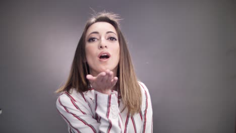 attractive young female blows kiss. face close up