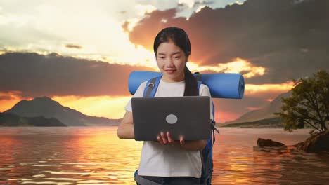 woman with laptop at sunset lake