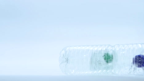 a clear plastic bottle on a light background with small blue and green objects inside