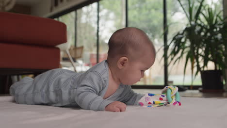 Baby-Auf-Dem-Bauch-Spielt-Mit-Spielzeug