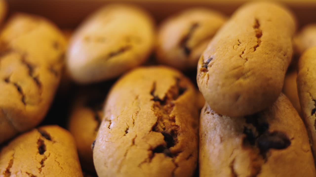 Pile of baked golden biscuits with grain flavor an chocolate chips, close up shot