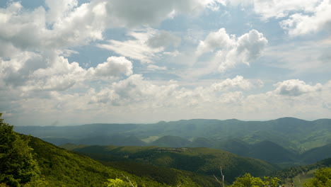 clouds moving over a valley of mountains