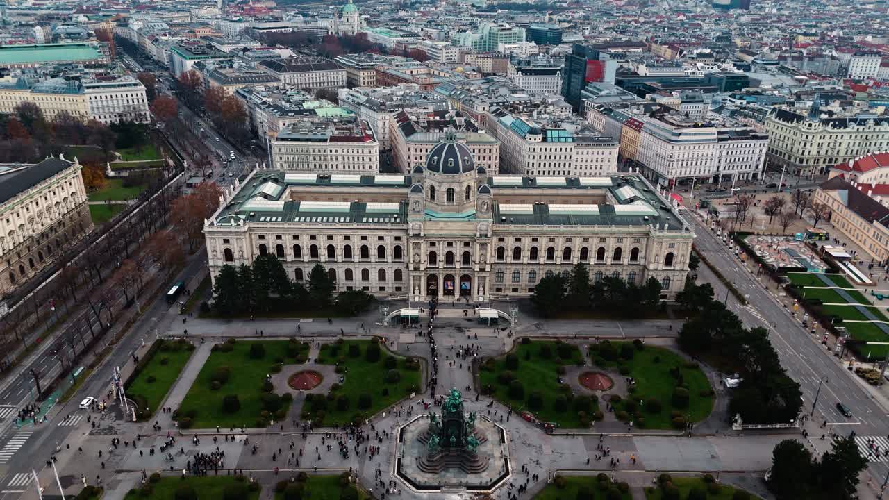 Ripresa aerea statica con drone del Museo di storia naturale di Vienna in Austria, che mostra la sua imponente facciata e le strade circostanti, con edifici e tetti illuminati dalla luce solare invernale