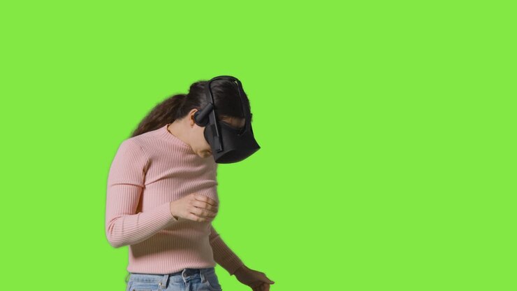 Donna che indossa un visore per la realtà virtuale, su sfondo green screen in studio 1.