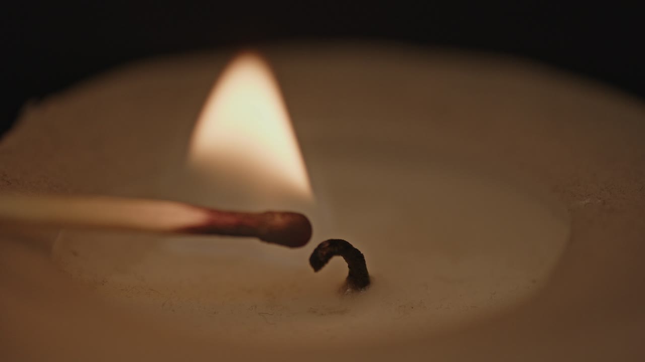hermosa vista macro de una vela encendida por un fósforo en llamas