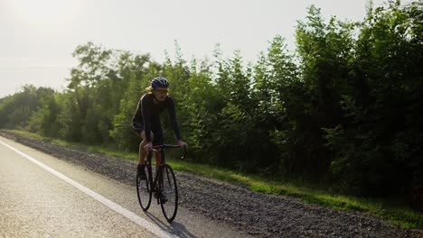 male cyclist in helmet rides bicycle along an empty track, slow motion