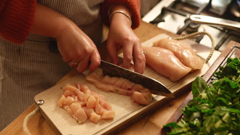 woman chopping chicken for dinner