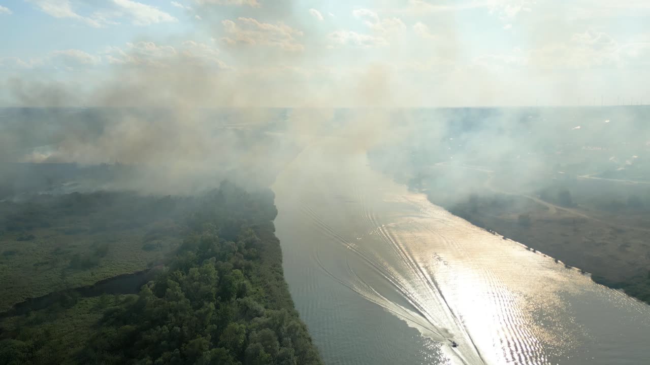 Wildfire spreads along the Odra River in Poland as smoke rises into the sunny sky