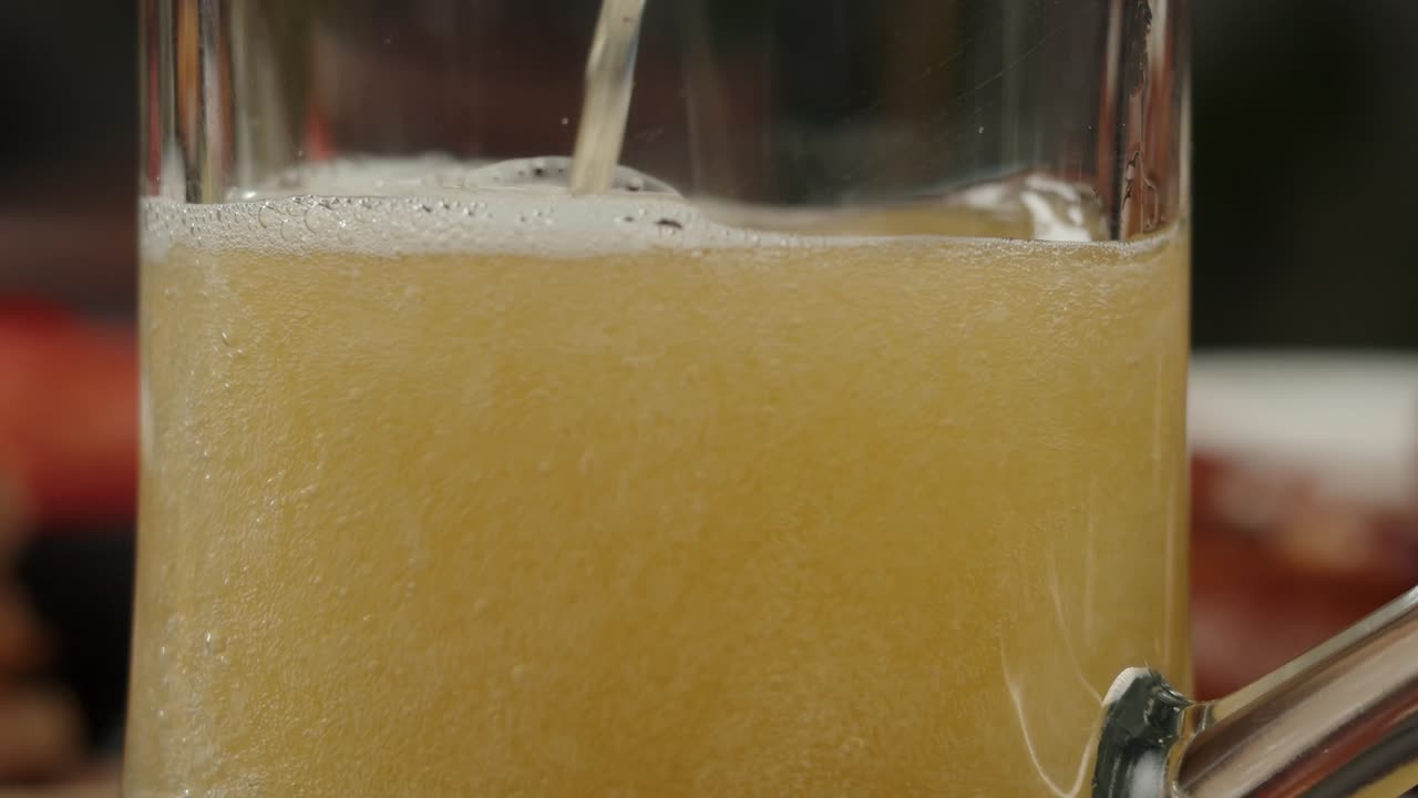 Primo piano di birra versata in un boccale di vetro