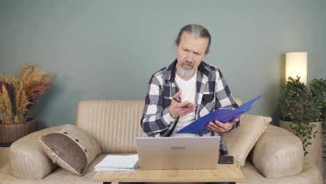 el hombre que trabaja en la computadora portátil lanza archivos enojado.