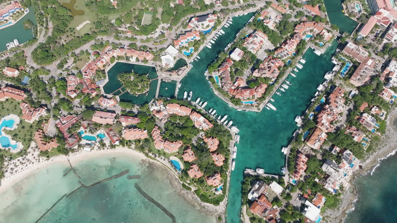 Stunning Bird's-Eye View of a Marina Featuring Yachts, Holiday Condominiums, and a Serene Sea with Shadows of Passing Clouds