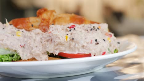 sándwich de atún con mayonesa en un plato en la mesa