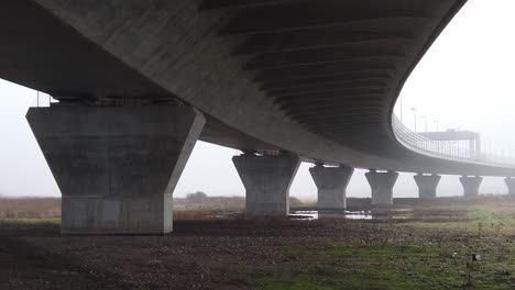 ghostly misty concrete support structure under motorway flyover