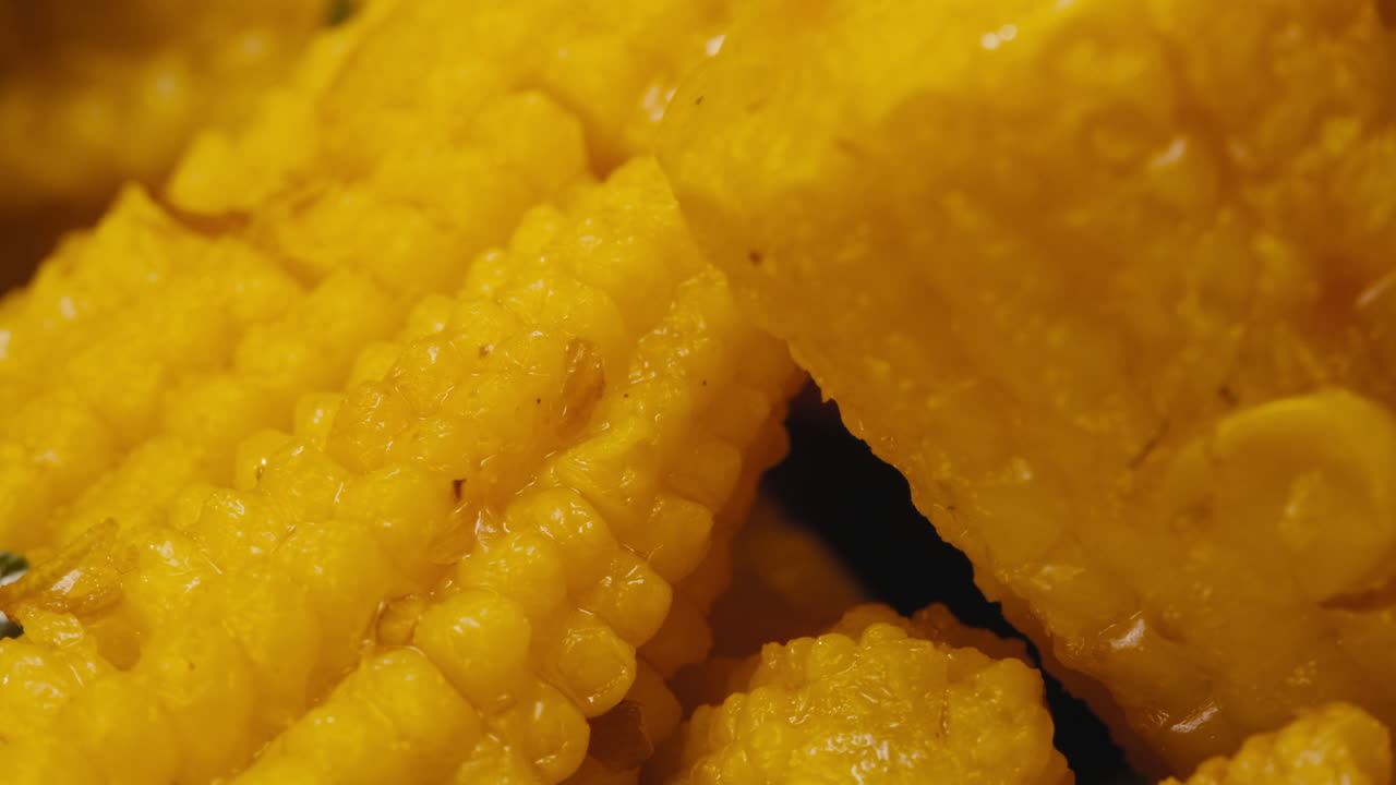 Close-up of fermented yellow mini corn with black pepper on plate. Preservation of vegetables in glass jars. Fermentation preserved mini corns with spices macro.
