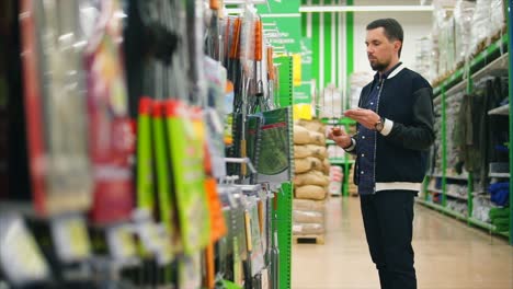 hombre comprando herramientas de jardinería en una tienda
