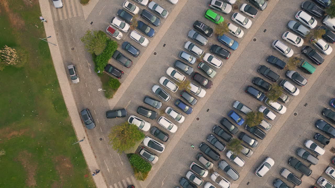Crowded city parking drone view. Diverse cars riding at asphalt road to carpark