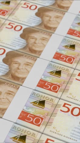 vertical video of 50 swedish krona banknotes printing by a money press