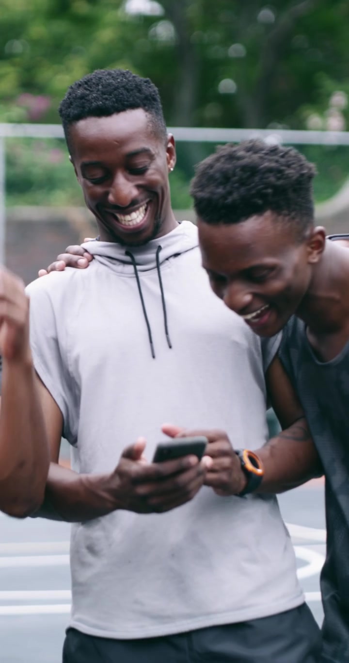 Group of Young Men Looking at Smartphone on Basketball Court