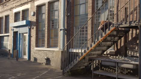 person sitting on metal staircase outside the bussey building on copeland road in peckham south london uk 1