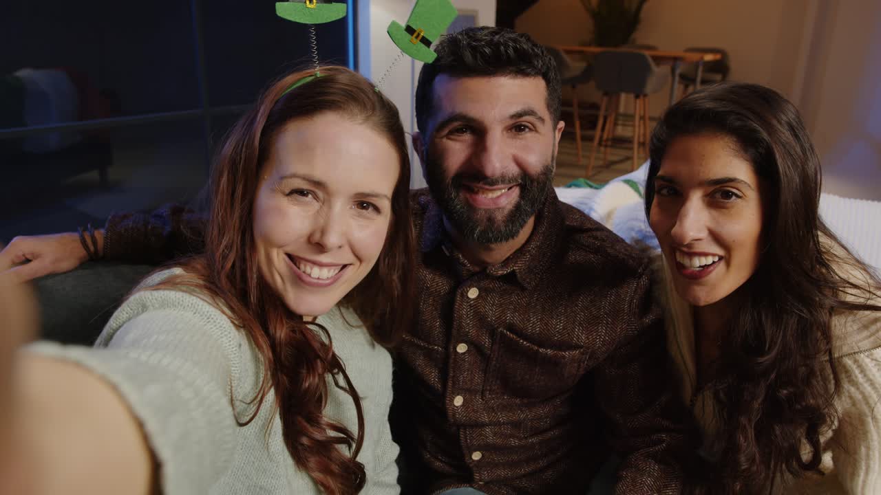 fotografía de amigos disfrazados con novedades y accesorios irlandeses en casa o en el bar posando para selfies celebrando la fiesta del día de san patricio