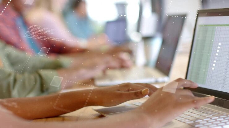 Team typing at laptops, typing sparking code overlays over hands and screen showing business table