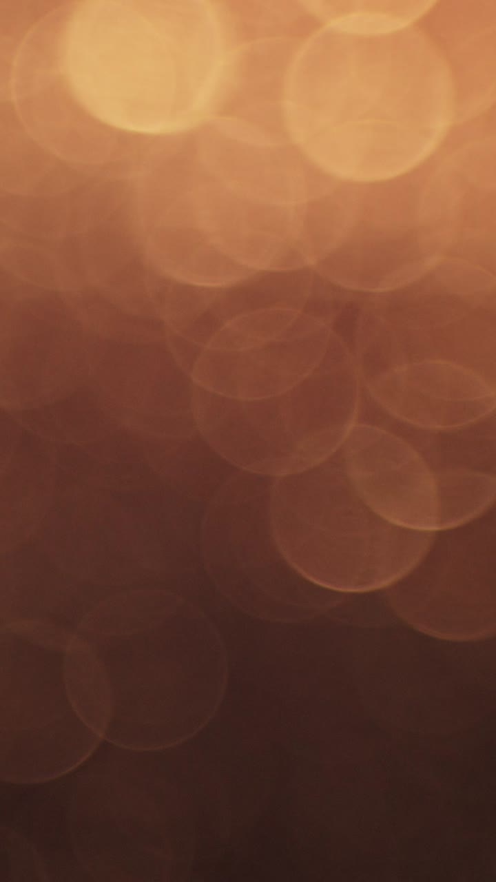 Luci bokeh calde che si dissolvono su sfondo scuro