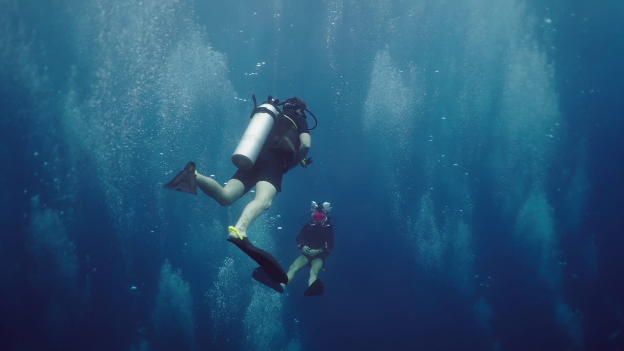 Two Scuba Divers Exploring the Deep Blue Underwater