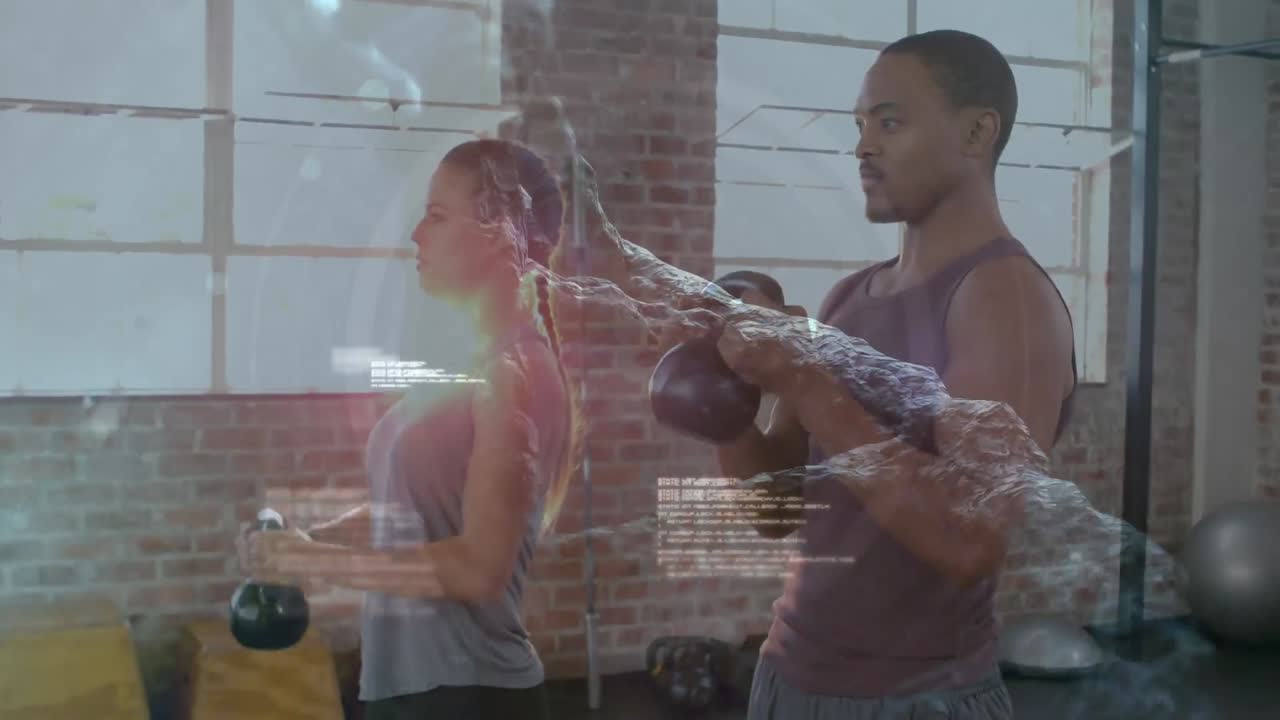 procesamiento de datos médicos contra una pareja de raza mixta que hace ejercicio con kettlebells en el gimnasio