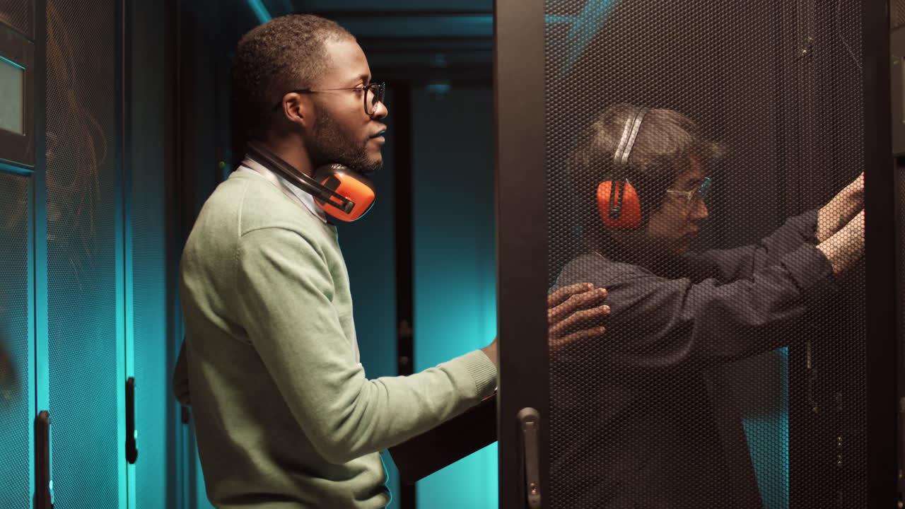 Pair of IT Engineers Having Talk in Server Room