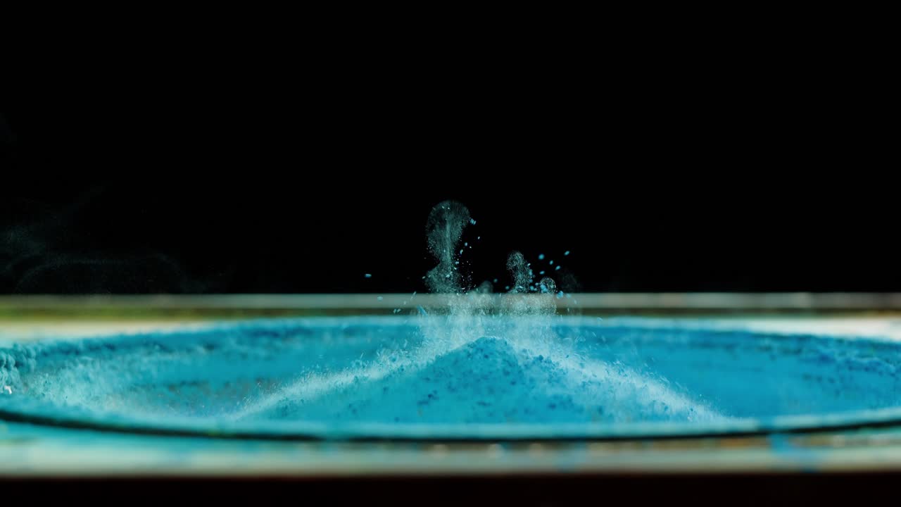 Polvo azul vibrante bailando sobre el cono de un altavoz