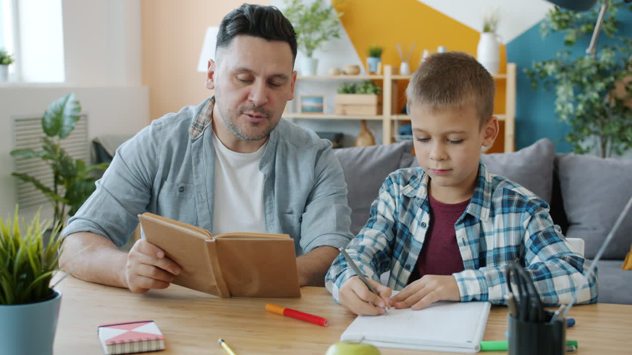 Father and son doing homework together at home