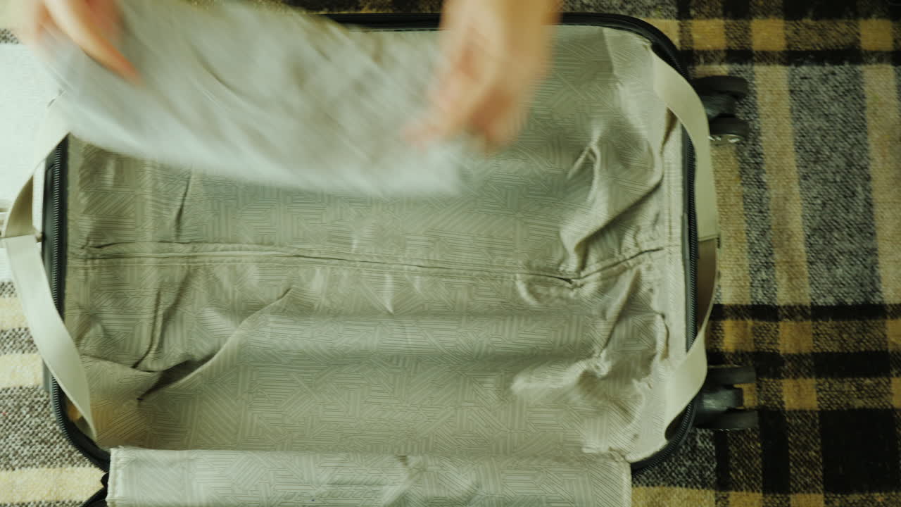 한 여성이 여행용 가방을 싸고 있다