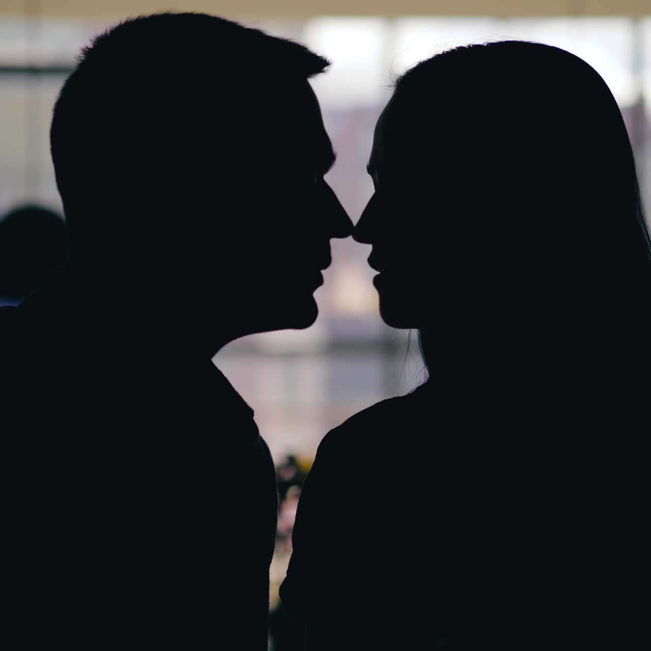 romantic couple are kissing in the cafe at table in the day. Motion of silhouettes