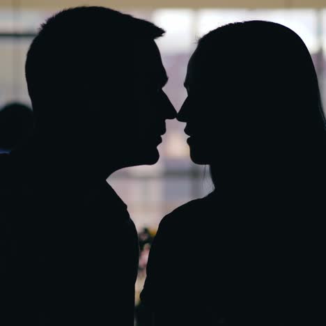 ein romantisches paar küsst sich am tag am tisch im café. bewegung der silhouetten