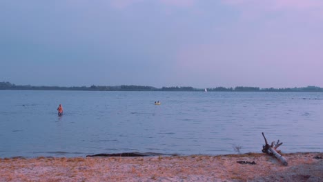 a beautiful view of waters with a purple hue as the sun sets at beach. flevoland, netherlands
