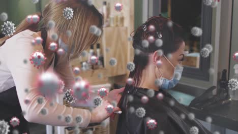 Animation-of-coronavirus-cells-over-caucasian-female-hairdresser-and-woman-wearing-face-masks