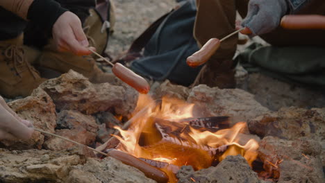 Hands-Of-A-Group-Of-Teenage-Friends-Roasting-Sausages-On-The-Bonfire