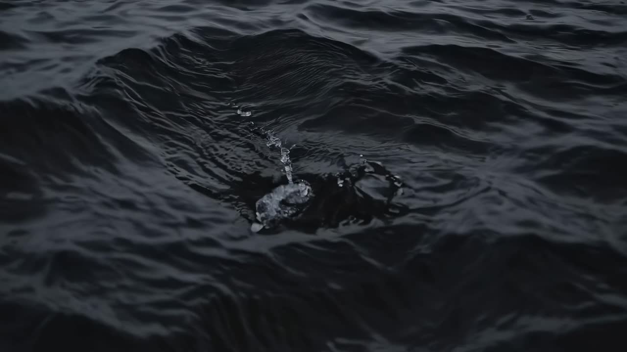 Video bernuansa melankolis tentang laut gelap bergelombang di bawah langit berawan, diambil dari sudut rendah