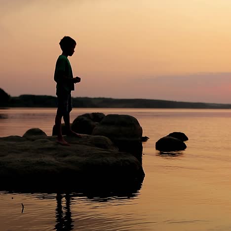 Boy Playing On Beach At Sunset