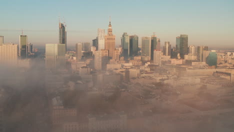 Erstaunliche-Aufnahme-Des-Panoramas-Der-Innenstadt,-Das-Aus-Dichtem-Nebel-Herauskommt.-Gruppe-Von-Hochhäusern,-Die-Von-Der-Morgensonne-Beleuchtet-Werden.-Warschau,-Polen