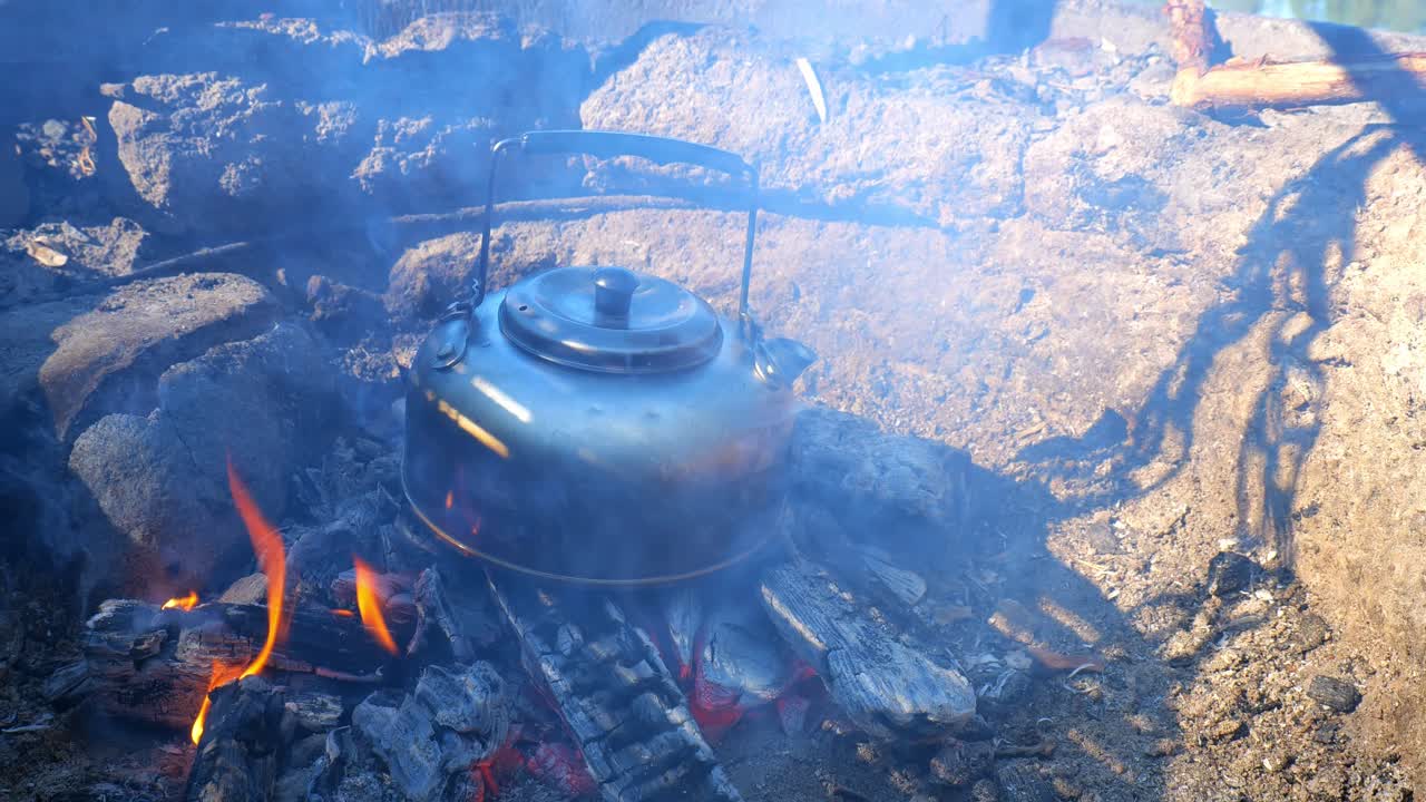 Close-Up of a Kettle Heating on Glowing Campfire Embers